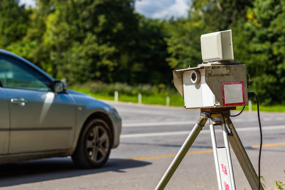 mobile-speed-camera-device-working-summer-daytime-road-with-blurry-silver-car-background-view-from-back